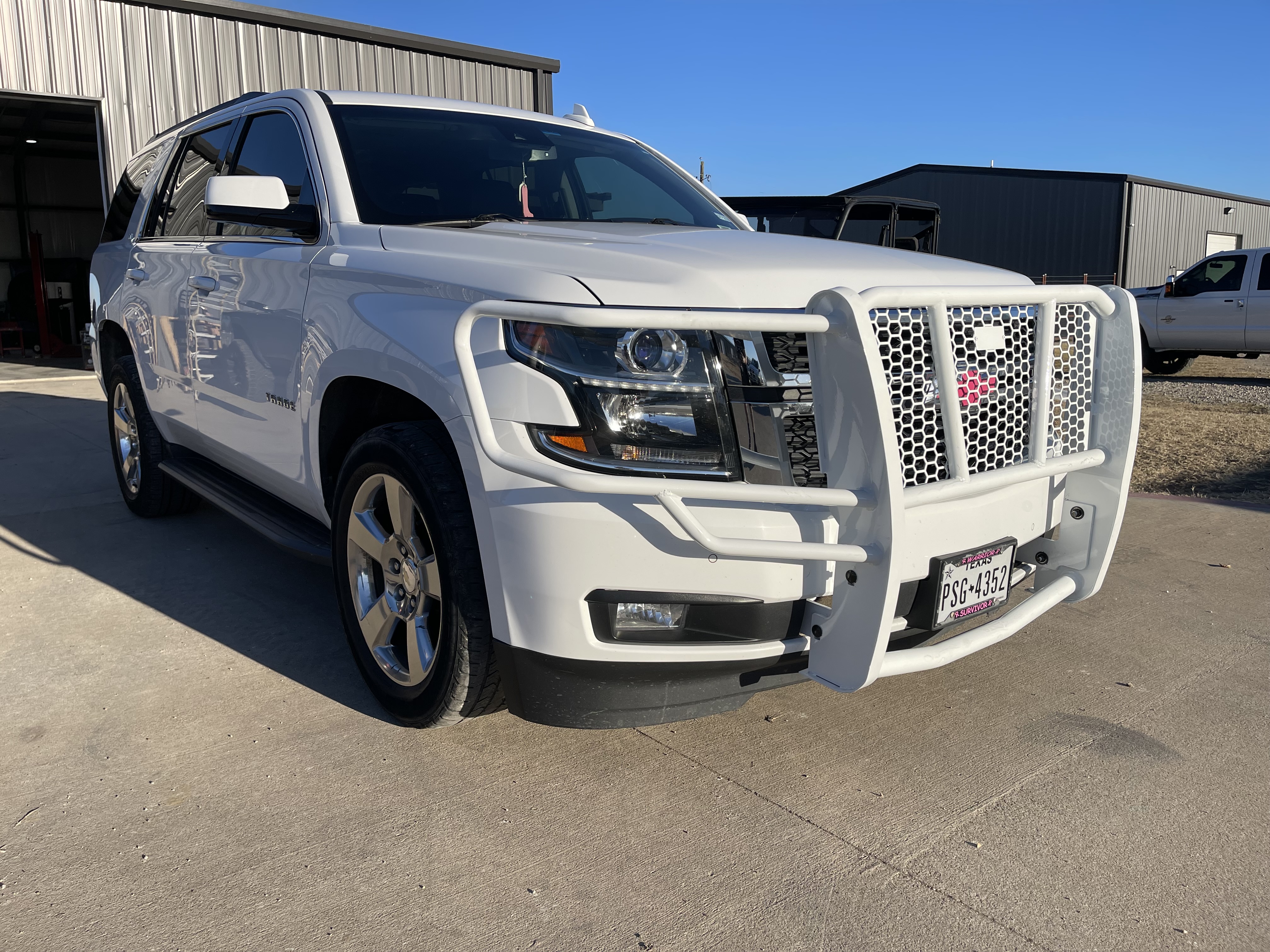 White Chevy Tahoe with custom white grille guard and brush guard