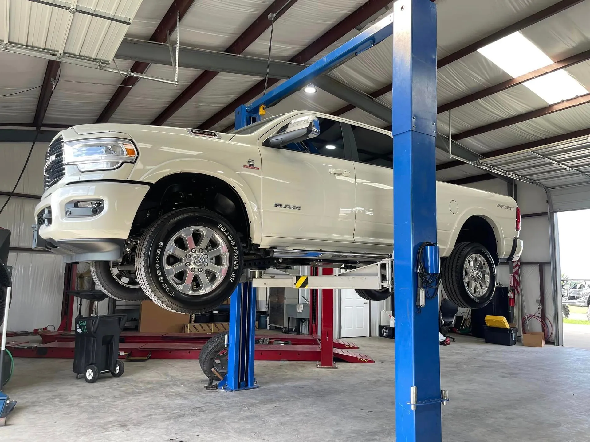 White RAM truck on professional automotive lift in service bay